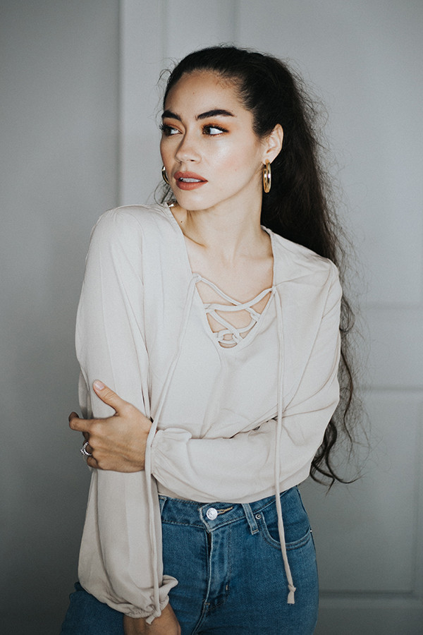 TAN BODYSUIT. WHO DOESN’T LOVE A BODYSUIT? TIE UP DETAIL AROUND NECKLINE AND NOT AN ULTRA TIGHT FITTING BODY LIKE MOST BODYSUITS.