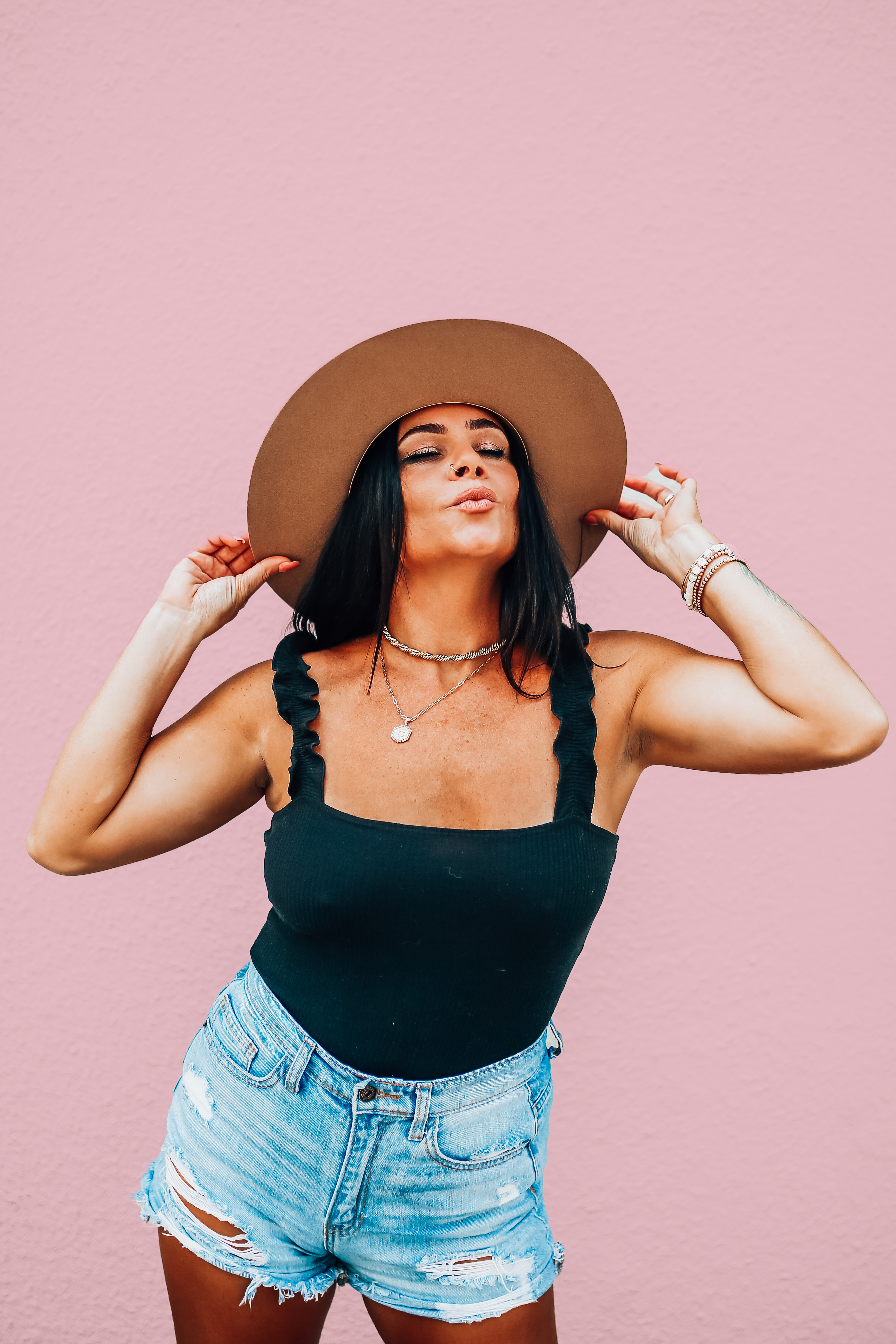 LOOSER FIT THAN OUR ORIGINAL AND BOTTOM IS A LITTLE FULLER COVERAGE. BLACK BODYSUIT WITH RIBBING AND RUFFLED STRAPS. STRETCHY AND ELASTIC IN THE STRAPS. 95% POLYESTER, 5% SPANDEX.