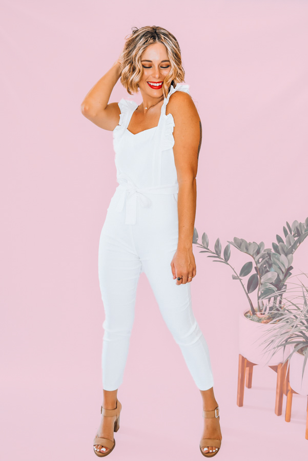 WHITE RUFFLE TANK JUMPER WITH TIE WAIST. WE RECOMMEND WEARING NUDE SPANX OR SIMILAR TO AVOID UNDERGARMENT LINES SHOWING THROUGH THIS WHITE FABRIC. AMANDA IS WEARING THEM IN THE PHOTO 90% POLYESTER, 10% SPANDEX. AMANDA IS 5’6 SIZE 2, WEARING A SMALL.