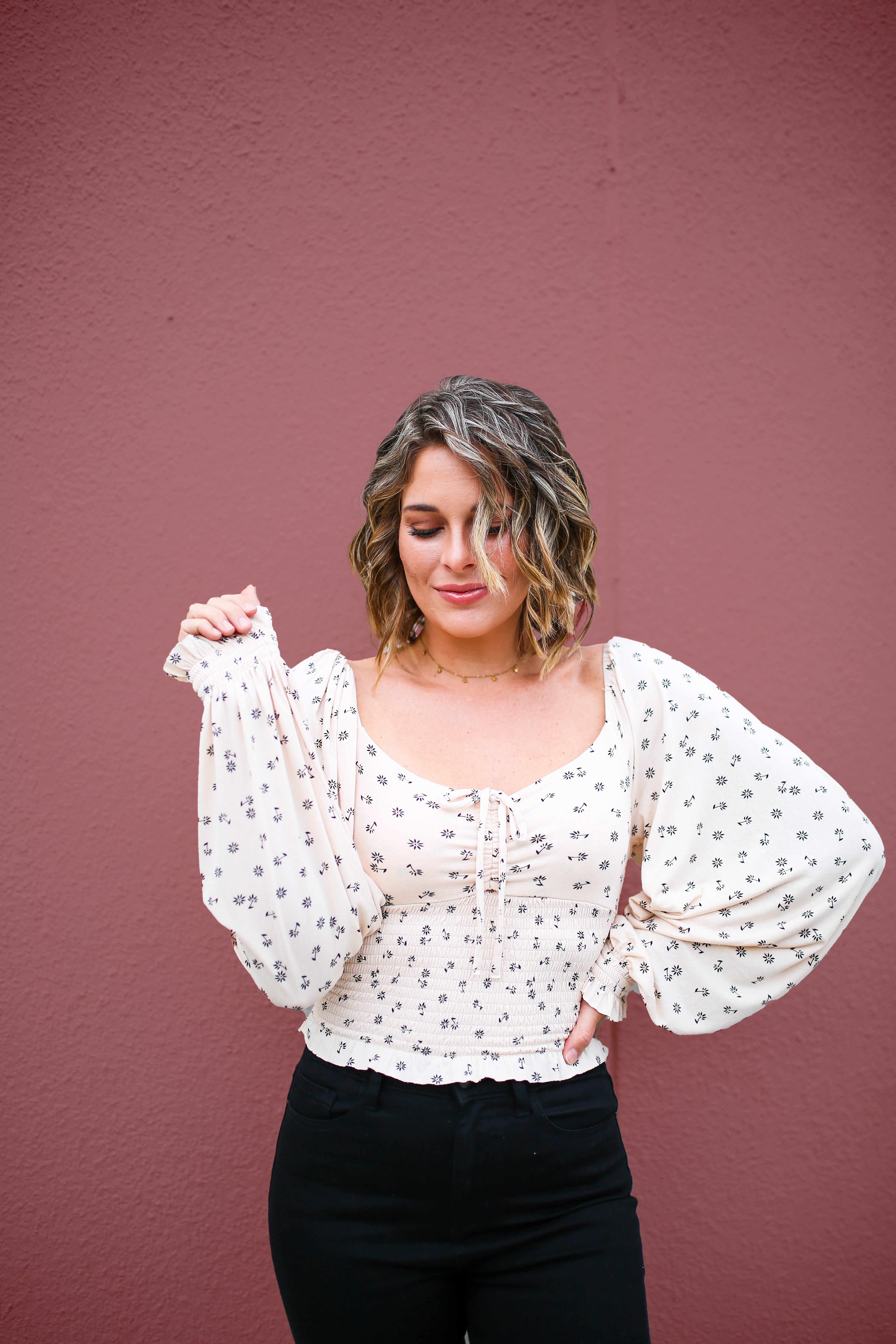 CREAM COLORED TOP WITH BLACK FLORAL PATTERN. FULL LENGTH, FLOWY BUBBLE SLEEVES WITH CINCHING AT WRIST. ELASTIC BODICE WITH ADJUSTABLE TIE AT BUST. VERY STRETCHY AND SOFT MATERIAL. 96% RAYON, 4% SPANDEX.