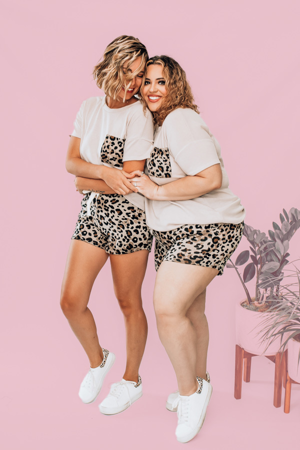 SHORT SLEEVE FLEECE TOP AND SHORTS. MOCHA COLOR TOP WITH LEOPARD POCKET DETAIL. LEOPARD SHORTS WITH ELASTIC WAIST AND NONFUNCTIONAL TIE. 78% POLYESTER 18% RAYON 4% SPANDEX. NIKKI IS SIZE 14, WEARING XL. AMANDA IS A SIZE 2, WEARING A SMALL.